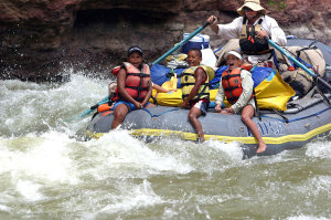 folks in river raft in white water rapid